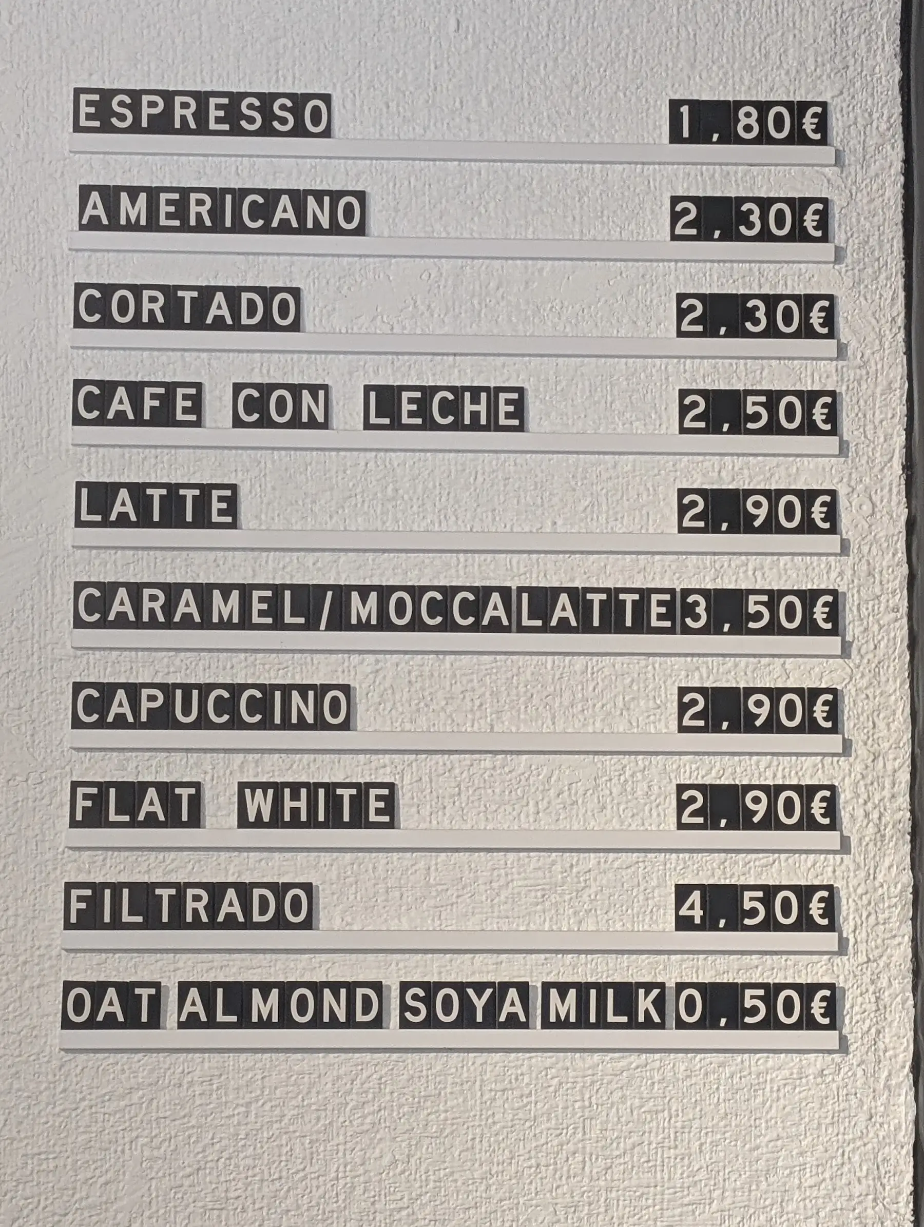 La pizarra de letras de la pared con los cafés y sus precios